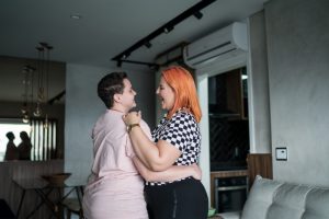 young-couple-smiling-and-dancing-in-front-of-a-mini-split-air-handler